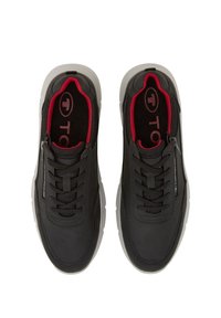 Chaussures de sport noires en matériau texturé, design à lacets, doublure intérieure rouge contrastante et semelle en caoutchouc blanche.