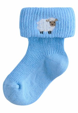 Lys blå strikket sok med ribbet tekstur, med et broderet fåredesign på folden. Glat materiale med en afrundet tå.