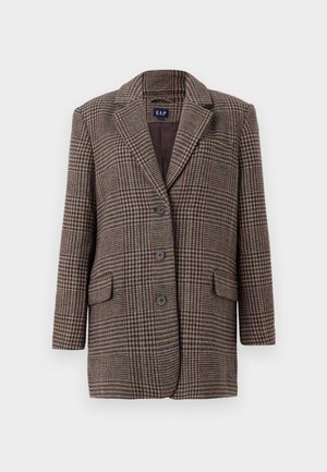 Braun-beige Hahnentrittmuster-Blazer mit drei Knöpfen, zwei vorderen Klappentaschen und einem eingekerbten Kragen, der vor einem weißen Hintergrund hängt.
