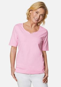 Rosa Kurzarm-T-Shirt mit V-Ausschnitt und dekorativen Nieten am Kragen. Hergestellt aus weichem Stoff bietet es einen lockeren Sitz.