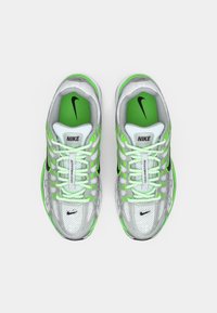 Nike tenisice za trčanje s gornjim dijelom od srebrne mrežice s zelenim akcentima, podstavljenim jezikom i zelenom unutrašnjosti, s detaljima u crnoj boji.