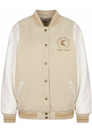 Beige varsity-jakke med hvite faux lærermansjetter, stripete ribbede mansjetter og hem, brodert logo på venstre bryst, og trykknapp-lukking.