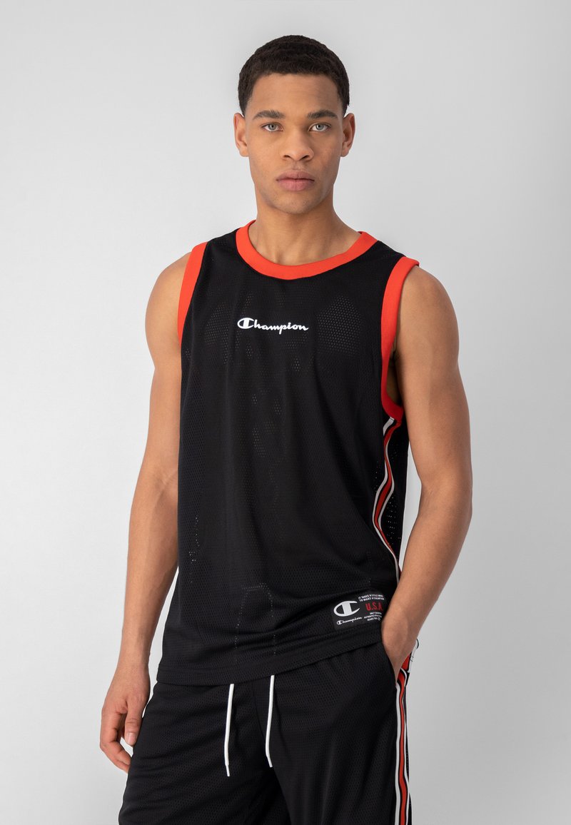 Top sin mangas de malla negra con acentos rojos, que presenta un escote redondo y un logo, combinado con pantalones cortos negros que tienen cordones blancos.