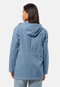 Lichtblauwe, waterdichte jas met een capuchon, lange mouwen en een trekkoord. Gladde textuur, ontspannen pasvorm en een middenlange ontwerp.