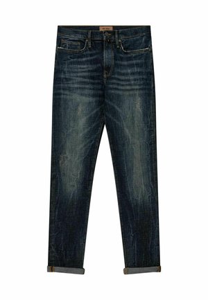 Tmavomodré rifle z džínsoviny so zvlneným, opotrebovaným vzhľadom, s rovnými nohavicami a zarolovanými manžetami. Obsahujú predné vrecká a pás.