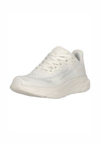 Weiße Sportschuh mit einem atmungsaktiven Mesh-Obermaterial, strukturiertem Design und gepolsterter Sohle; verfügt über Schnürsenkel und eine gebogene Zehenkappe.