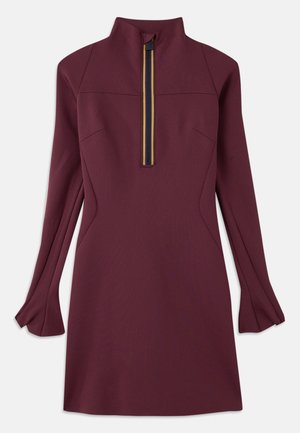 Robe mauve avec un col montant et une demi-fermeture éclair ornée d'une bande multicolore. Manches longues avec poignets évasés, texture lisse.