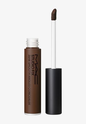 Tube de correcteur liquide marron avec un capuchon noir et un applicateur blanc, étiqueté "MAC Studio Fix 36HR Smooth Angles Concealer".