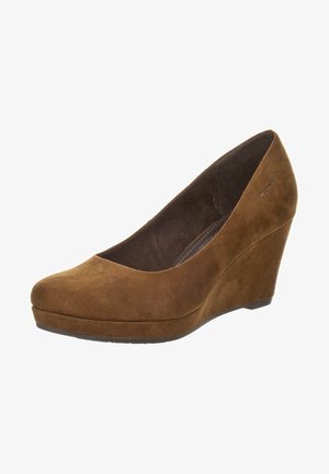 Braune Wildleder-Wedgeschuhe mit einer abgerundeten Zehenpartie, niedrigem Vorderteil und einer strukturierten Oberfläche. Der Keilabsatz ist leicht erhöht und hat eine dunkle Sohle.