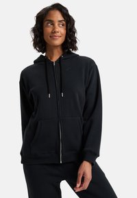 Felpa nera con zip realizzata in tessuto morbido, dotata di cappuccio, due tasche frontali e un piccolo logo sul petto. Design semplice con polsini a costine.