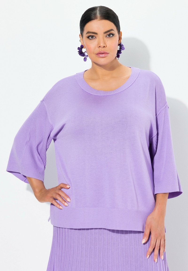 Maglione lavorato a maglia di un delicato colore viola chiaro, con un ampio scollo a costine e maniche 3/4. Il tessuto ha una texture morbida e una vestibilità rilassata.