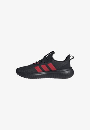 Black athletic sneaker with red three-stripe design, knit upper, pull tab on heel, and thick black grooved sole.