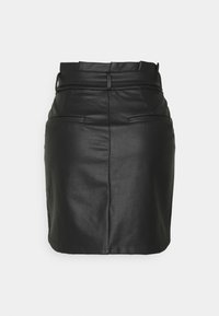 Svart läderkjol med hög midja, framfickor och en åtsittande silhuett. Har en slät textur och en subtil glans.