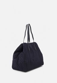 Duża granatowa torba z tkaniny o teksturowanej powierzchni, z dwoma długimi skórzanymi uchwytami i miękkim, składanym kształtem. Brak widocznych metalowych elementów czy ozdób.