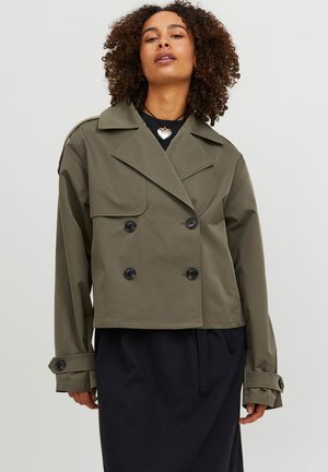 Olivengrønn cropped jakke med doble knapper, store reverser og svarte knapper; kombinert med marineblå bukser med snorer.