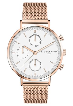 Montre ronde avec un cadran blanc, bracelet en maille métallique rose doré, trois sous-cadrans pour la date et le jour, et des marqueurs d'heure minimalistes.