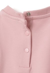 Lichtroze katoenen kledingstuk met een ribbelkraag, twee drukknoopjes en een gladde textuur. Heeft een ronde halslijn en nette stiksels.