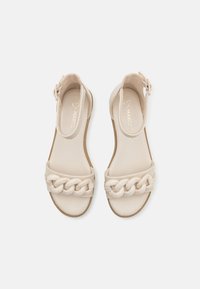 Beige Sandalen mit geflochtenem Riemendesign, verstellbarem Knöchelriemen, glatter Textur und flacher Sohle. Geeignet für die Freizeit.