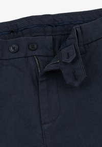 Marineblaue Stoffhose mit strukturiertem Gewebe, ausgestattet mit zwei schwarzen Knöpfen, einem Reißverschluss und einer verstärkten Gürtelschlaufe. Enthält eine Seitentasche.