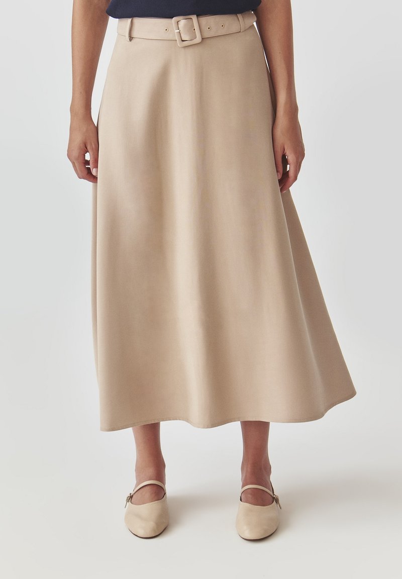 Beige A-lijn rok met een aansluitende taille en een brede riem met een vierkante gesp. Gladde textuur, knielengte, subtiel uitlopende zoom.
