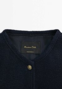 Mørkeblå uldblandet cardigan med rund hals og en enkelt gylden knaplukning; har et blødt, tekstureret stof og indvendigt mærke.