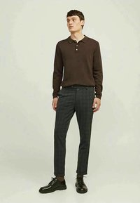 Brown long-sleeve polo shirt with a collar, paired with gray plaid tailored trousers and black lace-up shoes.