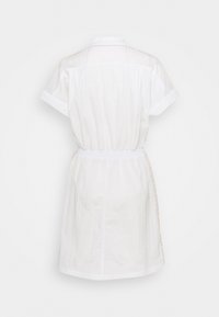 Biała sukienka na krótki rękaw z kołnierzykiem, elastycznym pasem i szczegółami w postaci bocznych pasków, przedstawiona z tyłu na jednolitym tle.