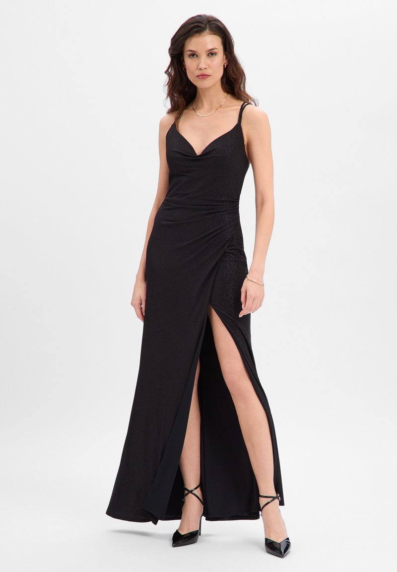 Robe noire longue jusqu'au sol, corsage ajusté, fines bretelles et fente latérale. Texture lisse avec des détails scintillants subtils.