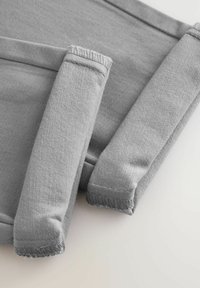 Tissu gris, présentant une texture rainurée et une finition douce. Comprend des sections rembourrées avec des bords cousus, disposées dans une mise en page plissée.