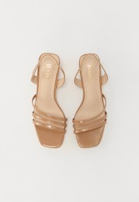 Beige sandaalit, joissa on neliömäinen kärki, kiiltävä patenttiviimeistely ja ohuet vaakasuorat hihnat. Brändäys sisäpohjassa.