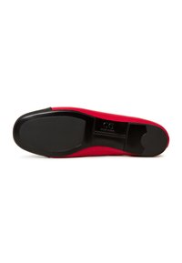 Suola rossa di scarpa con base nera liscia. Presenta una forma arrotondata e un bordo pulito. Contrassegnata con "GG" vicino al tallone. Manca di scanalature visibili.