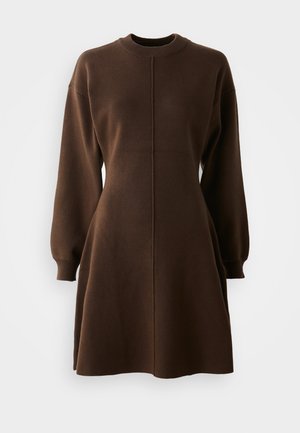 Brun langermet strikket kjole med tettsittende midje, rund hals og lett utvidet skjørt på ensfarget hvit bakgrunn.