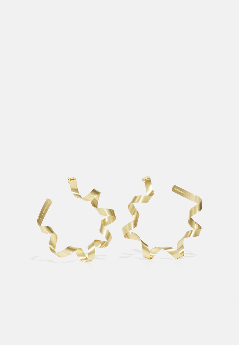 Boucles d'oreilles en spirale dorées au design ondulé, avec une finition métallique lisse et une forme ouverte. Légères et minimalistes.