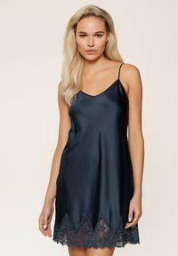 Abito sottoveste in satin blu navy con spalline a sottile, caratterizzato da un orlo in pizzo con bordo ondulato. La texture liscia e la finitura lucida esaltano il design.