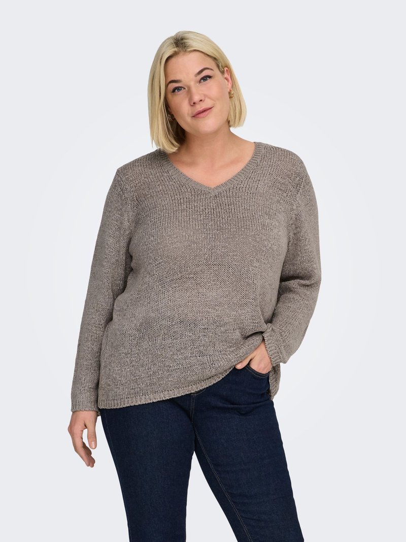 Light brown V-neck knit sweater with a loose fit, long sleeves, and textured fabric. Worn with dark blue jeans, minimalistic design.