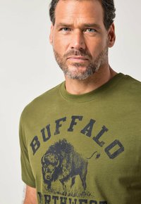 Zielona bawełniana koszulka z dużą czarną grafiką żubra i napisem "BUFFALO NORTHWEST", z okrągłym dekoltem i krótkimi rękawami.