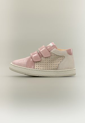 Zapatilla baja infantil con charol rosa y ante beige perforado, con dos correas de velcro y suela de goma blanca.