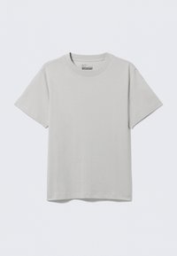 Tricou din bumbac gri deschis, cu gât rotund și mâneci scurte, având un design minimalist și o croială lejeră. Fără modele sau accente.