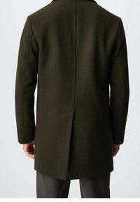 Donkergroen wollen overjas met een rechte snit, enkele split aan de achterkant en op maat gemaakte schouders. Soepele textuur, minimale hardwaredetails.