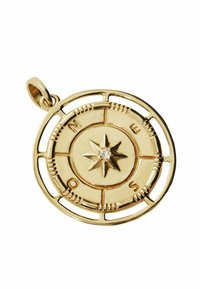 Colgante de brújula dorado que presenta una estrella central y direcciones cardinales grabadas. Diseño circular con un borde recortado y un pequeño acento de gema.