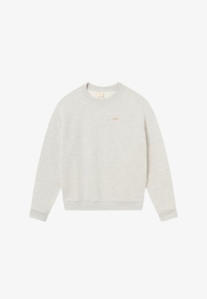 Svetlo šedá mikina vyrobená z mäkkej tkaniny, s okrúhlym výstrihom, rebrovanými manžetami a malým vyšitým logom v zlatej farbe na hrudi.