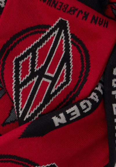 Pleteni šal v rdeči in črni barvi z geometrijskimi logotipi v kontrastnih barvah. Teksturirana tkanina z vračajočim se vzorcem ob robovih.