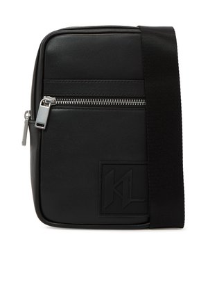 Čierna obdĺžniková crossbody taška so strieborným zipsovým vreckom, hrubým čiernym ramenným popruhom a vystúpeným logom na prednej strane.