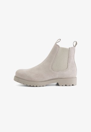Beige suede Chelsea-boot met elastische zijkanten en trekflappen, voorzien van een gestructureerde rubberen zool en een afgeronde neus.