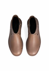 Stivali ankle in pelle marrone con finitura liscia, punta arrotondata e dettaglio con zip di lato. Suola in gomma piatta, design minimalista.