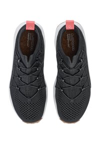 Sneaker nere lavorate a maglia con una parte superiore traspirante, lacci grigi, suola in gomma bianca e un'etichetta di presa rosa. Pattern testurizzati nell'area delle punte.