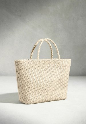 Kremfarvet flettet taske med to flettede håndtag, stående oprejst på en lys overflade mod en grå baggrund.