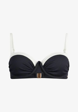Haut de bikini noir et blanc en tissu texturé, avec un soutien-gorge à armatures, un design devant torsadé et des accents en métal doré au centre.