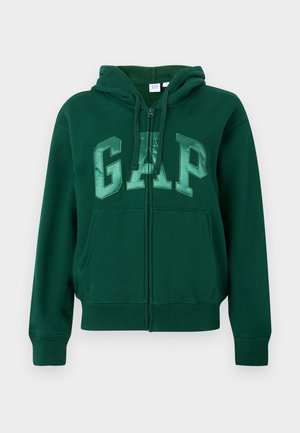 Sötétzöld, cipzáros kapucnis pulóver elülső zsebekkel, zsinóros kapucnival és nagy, fényes "GAP" felirattal a mellkason.