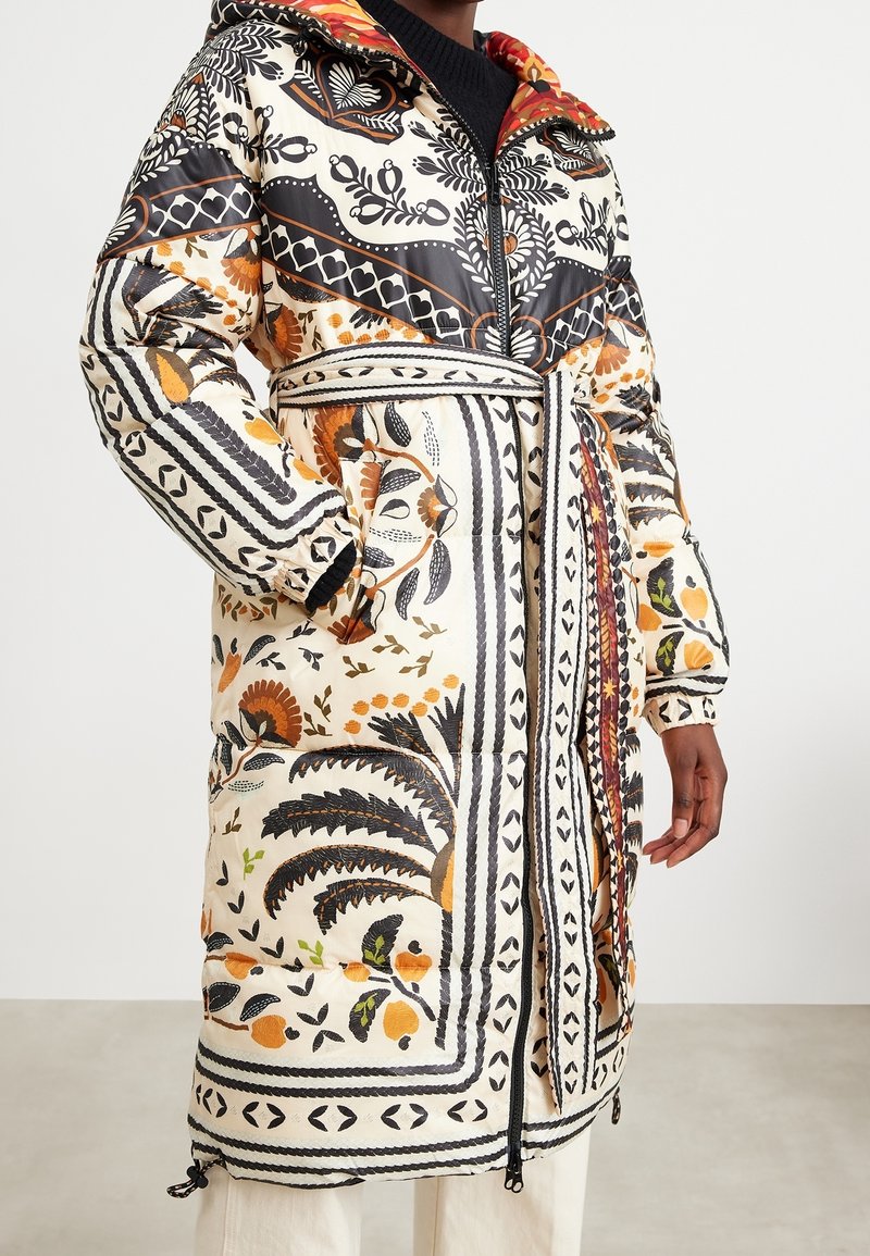 Abrigo largo acolchado con un estampado colorido de flores y formas geométricas, con capucha, cierre de cremallera y cordón ajustable en el dobladillo.